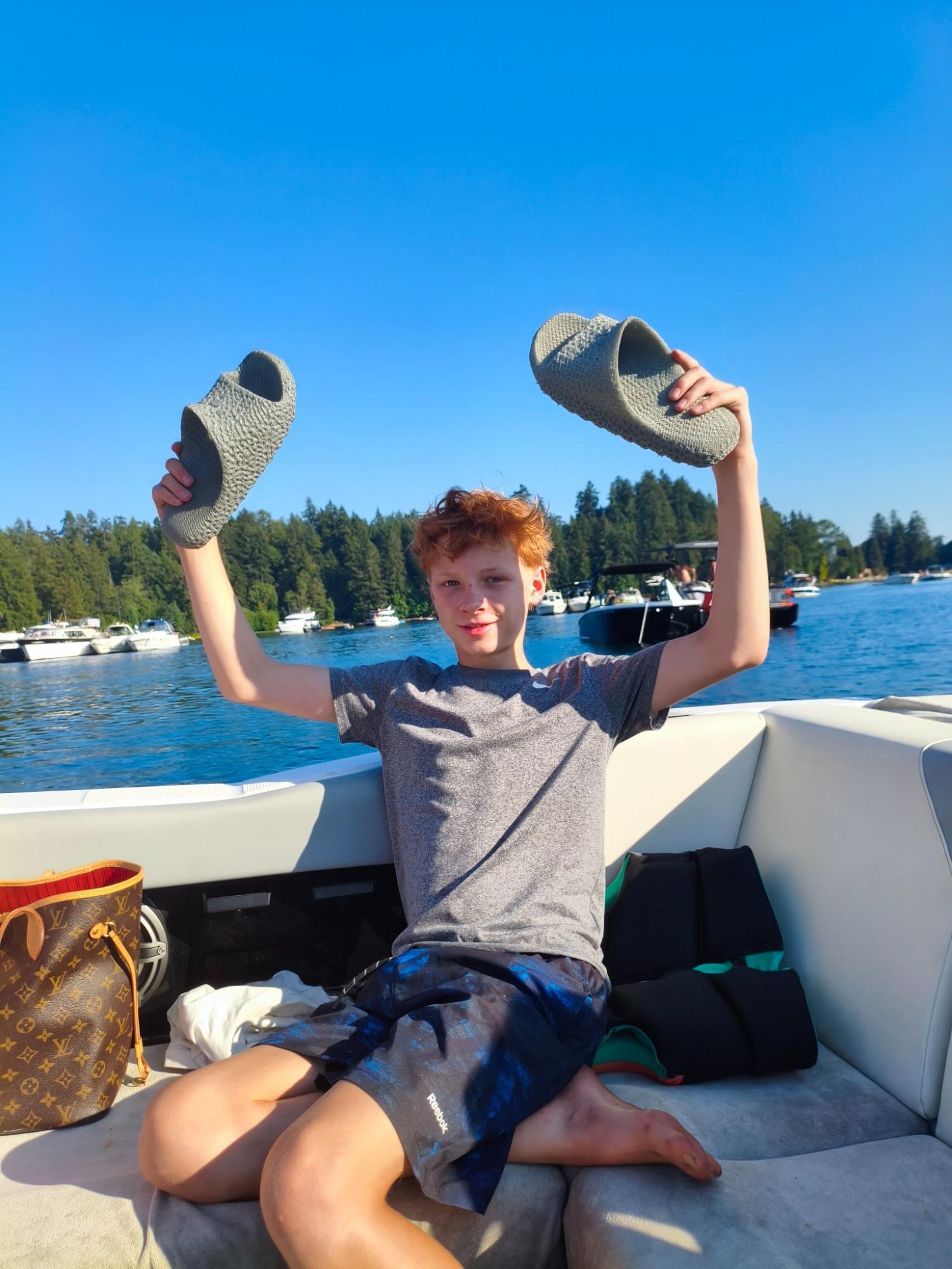 Person on a boat holding up a pair of Voronyz slides